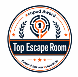 Rundes Abzeichen mit einem Labyrinth- und Schlüssellochmotiv, Lorbeerzweigen und Sternen. Der Text lautet: „xcaped Award, Top Escape Room, Empfohlen von xcaped.de“. Die Farben sind Blau, Orange und Weiß.
